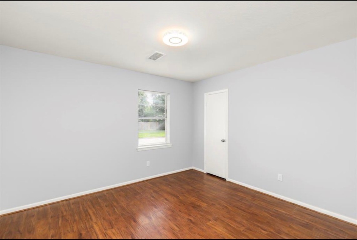 7515 Jason Street Houston, TX 77074 - Photo 19 of 24 a view of an empty room with wooden floor and a window