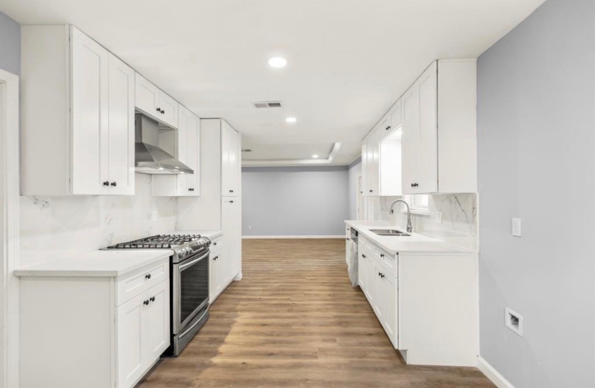 7515 Jason Street Houston, TX 77074 - Photo 4 of 24 a large white kitchen with a stove top oven