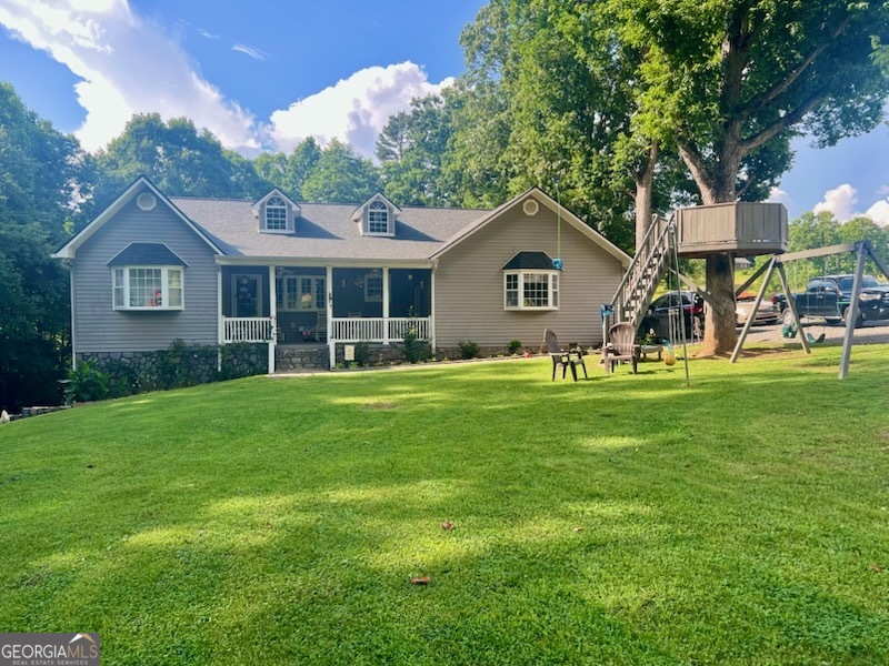 a front view of a house with a garden and trees
