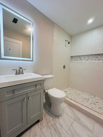 a bathroom with a granite countertop sink a toilet and a mirror