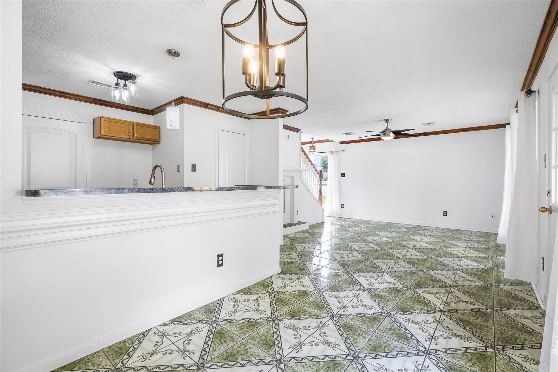 5426 Bourgeois Road Houston, TX 77066 - Photo 14 of 43 Bright and spacious living area featuring unique patterned tile flooring, elegant light fixtures, and an open layout with a view of the staircase.