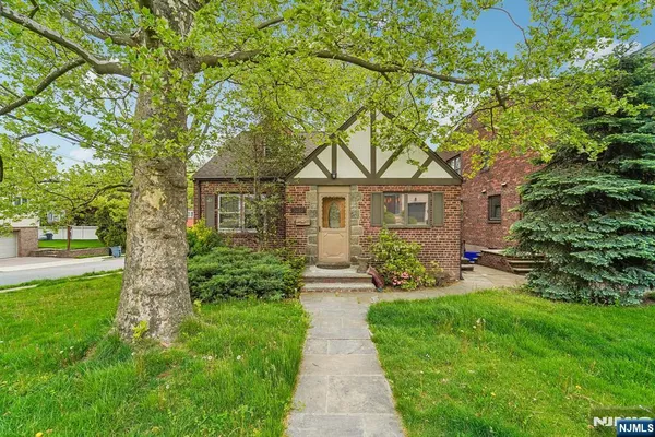 a front view of a house with yard and green space