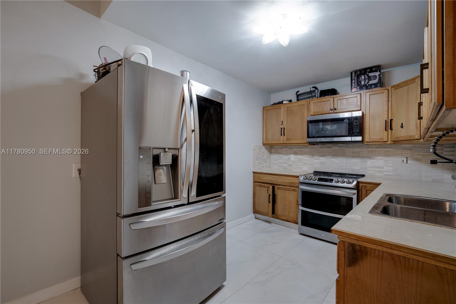 1114 Southwest 13th Court Miami, FL 33135 - Photo 35 of 43 a kitchen with granite countertop a refrigerator and a stove top oven