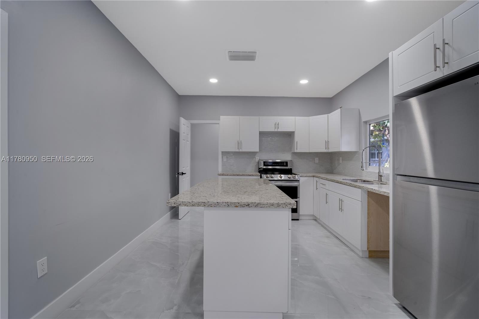 1114 Southwest 13th Court Miami, FL 33135 - Photo 8 of 43 a kitchen with a refrigerator a sink and cabinets