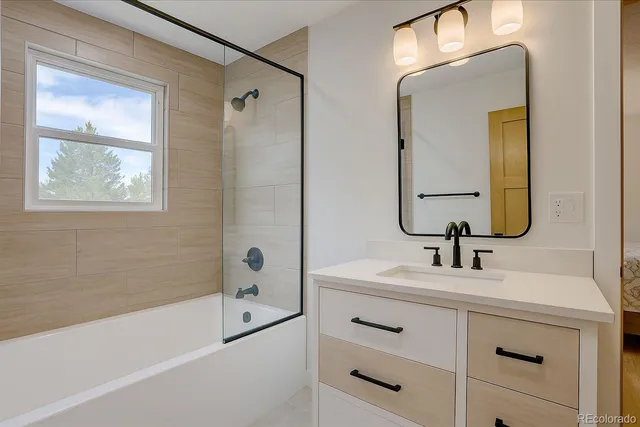 a bathroom with a double vanity sink mirror and bathtub