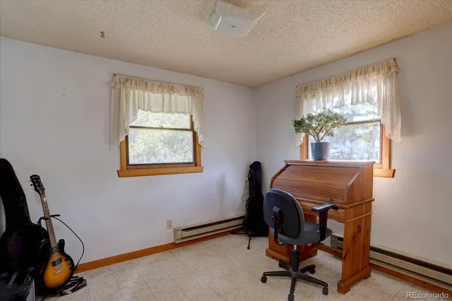 a view of a workspace with furniture and a window