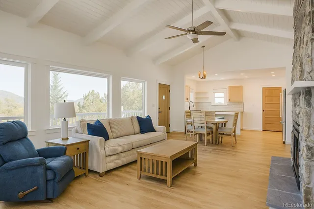 a living room with furniture a table and a large window