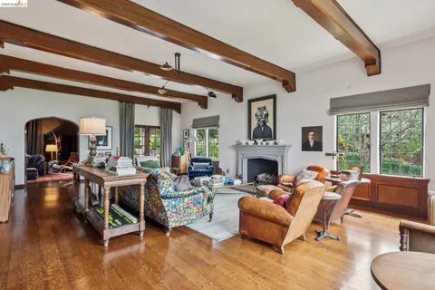 a living room with furniture a fireplace and large windows