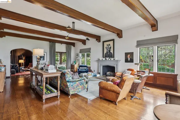 a living room with furniture a fireplace and large windows