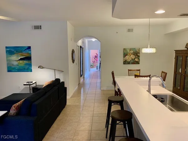 a living room with furniture a flat screen tv and a floor to ceiling window