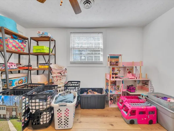 a room with furniture a rug toys and a window