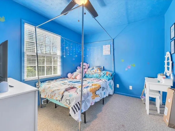 a bedroom with a bed table and window