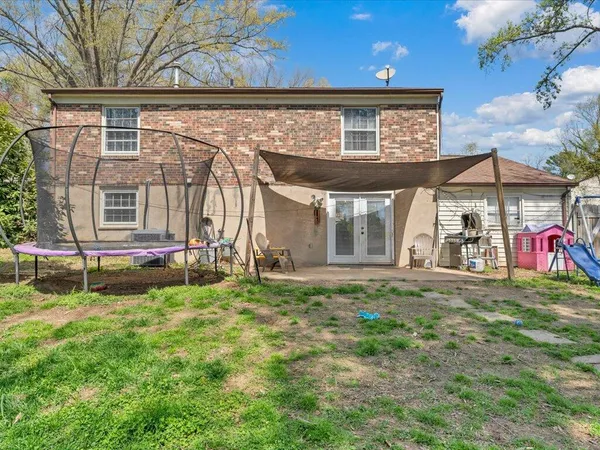 a backyard of a house with table and chairs