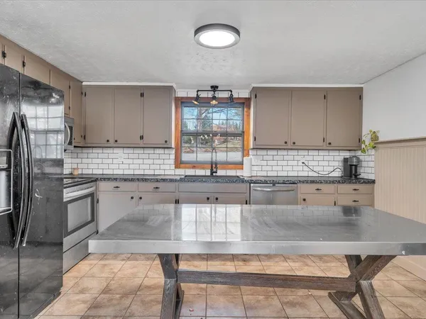 a kitchen with stainless steel appliances granite countertop a sink stove and cabinets