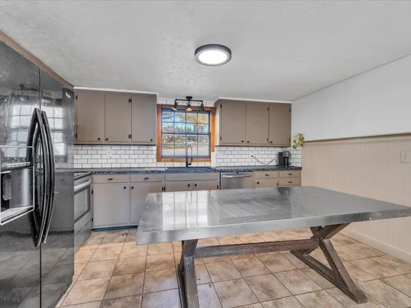 a kitchen with stainless steel appliances granite countertop a sink refrigerator and cabinets