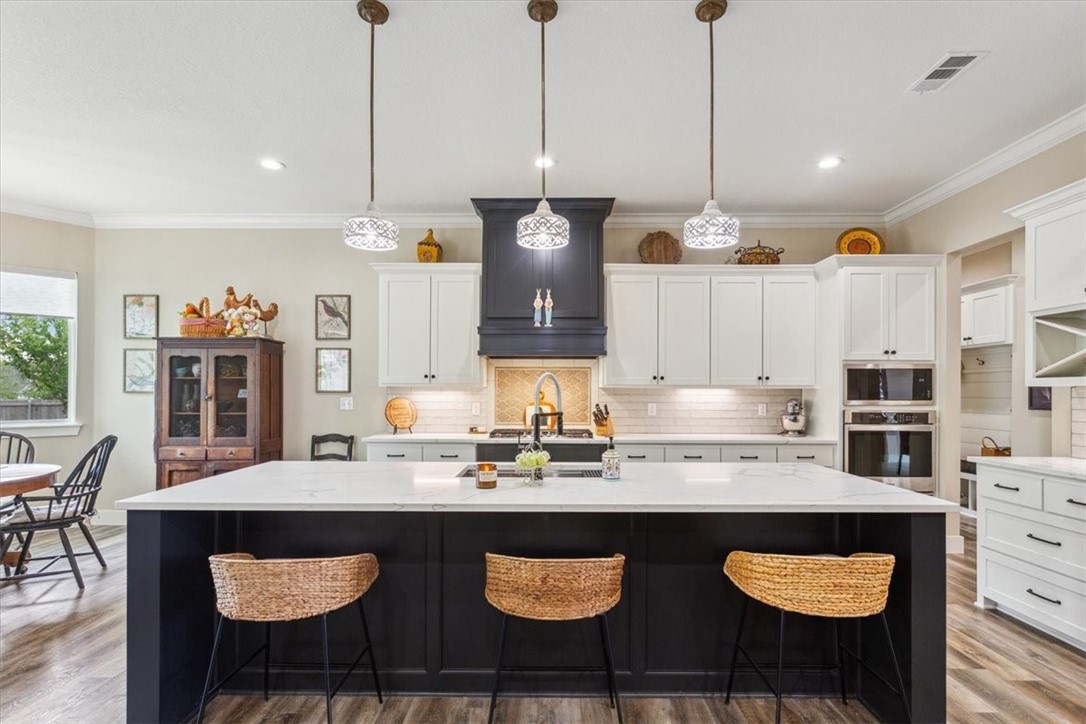 8 Independence Trail Waco, TX 76708 - Photo 14 of 39 a kitchen with stainless steel appliances granite countertop a sink a stove a dining table and chairs
