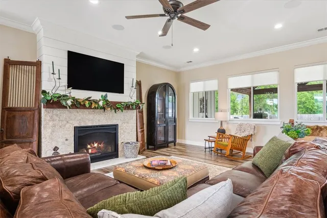 a living room with furniture fireplace and a large window