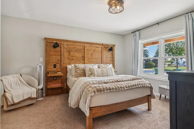a bed sitting in a bedroom next to a window