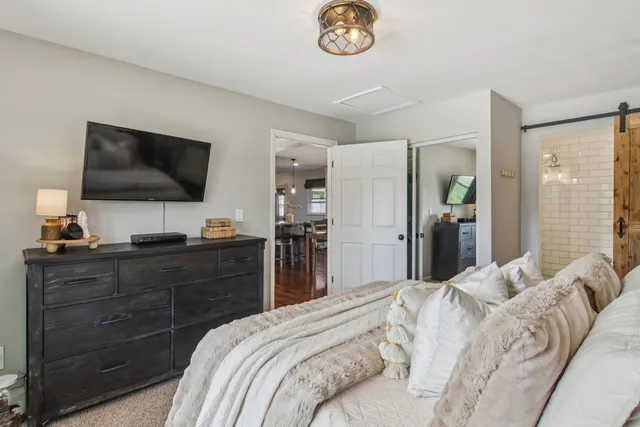 a bedroom with a bed and a flat screen tv