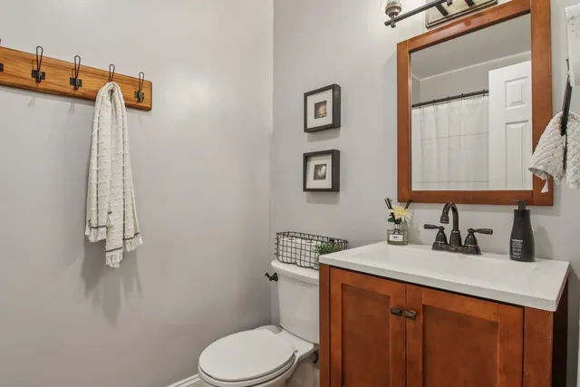 a bathroom with a granite countertop sink mirror vanity and toilet
