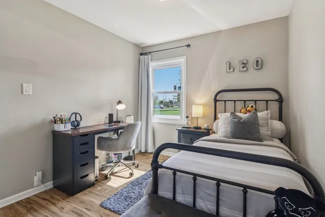 a bedroom with a bed and wooden floor