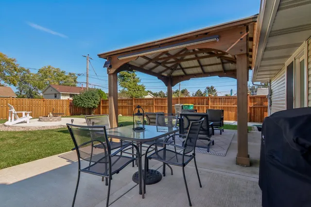 a view of patio with chairs and table under an umbrella