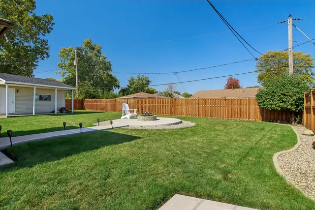 a view of a house with backyard and a tree