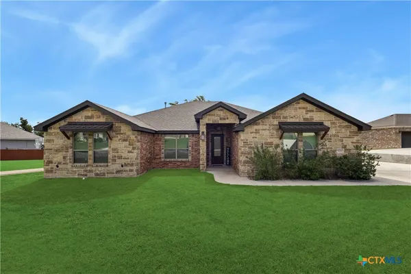 a front view of a house with a yard and garden