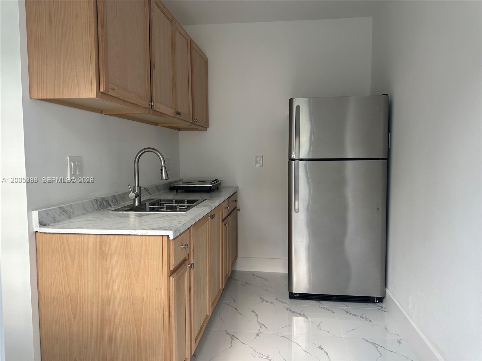 1765 Southwest 21st Street, Unit 3 Miami, FL 33145 - Photo 4 of 15 a kitchen with a refrigerator sink and cabinets