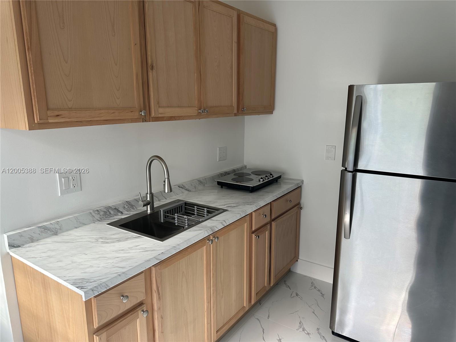 1765 Southwest 21st Street, Unit 3 Miami, FL 33145 - Photo 5 of 15 a kitchen with stainless steel appliances granite countertop a sink stove and refrigerator
