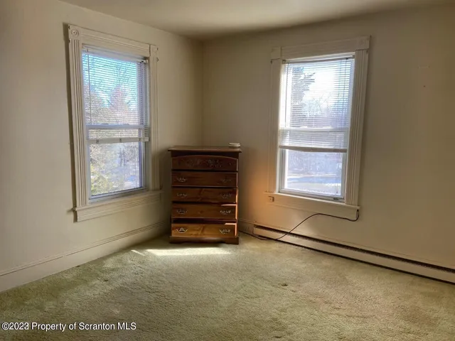 a room with a window and a dresser
