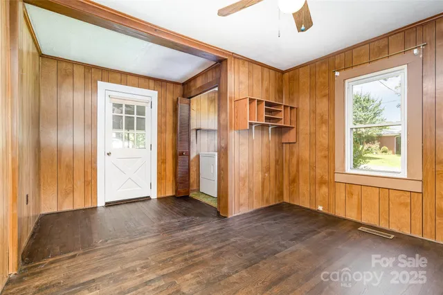 a view of a big room with wooden floor and windows
