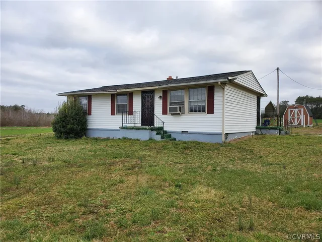 a view of a lush green forest with a house