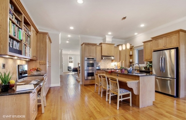2117 Harrison Street Evanston, IL 60201 - Photo 8 of 26 a kitchen with stainless steel appliances kitchen island granite countertop a refrigerator a stove a sink a dining table and chairs with wooden floor