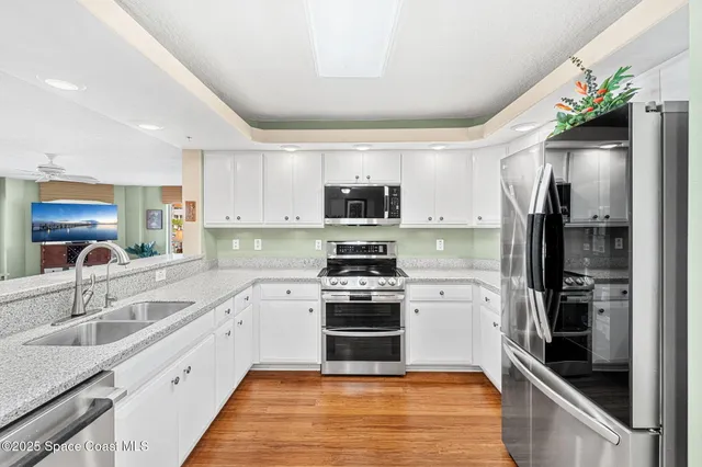 a view of a dining room and livingroom with furniture wooden floor a chandelier