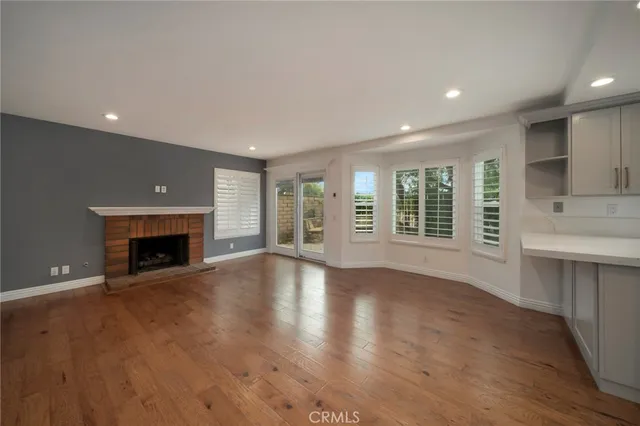 a view of an empty room with a fireplace and a window