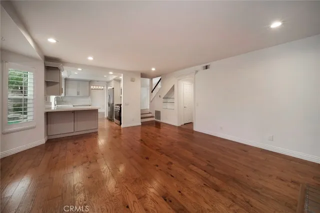 a view of large kitchen with wooden floor and windows