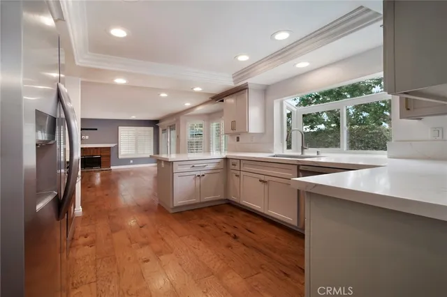 a kitchen with stainless steel appliances granite countertop a sink a stove and a refrigerator