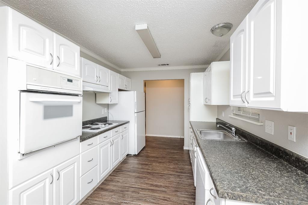 3001 Rufe Snow Drive Richland Hills, TX 76118 - Photo 6 of 15 a kitchen with stainless steel appliances kitchen island granite countertop a stove a sink and a refrigerator