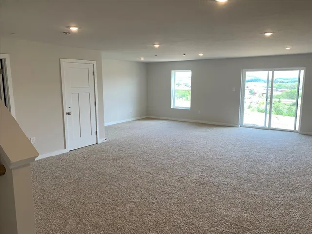 a view of a big room with windows and chandelier fan