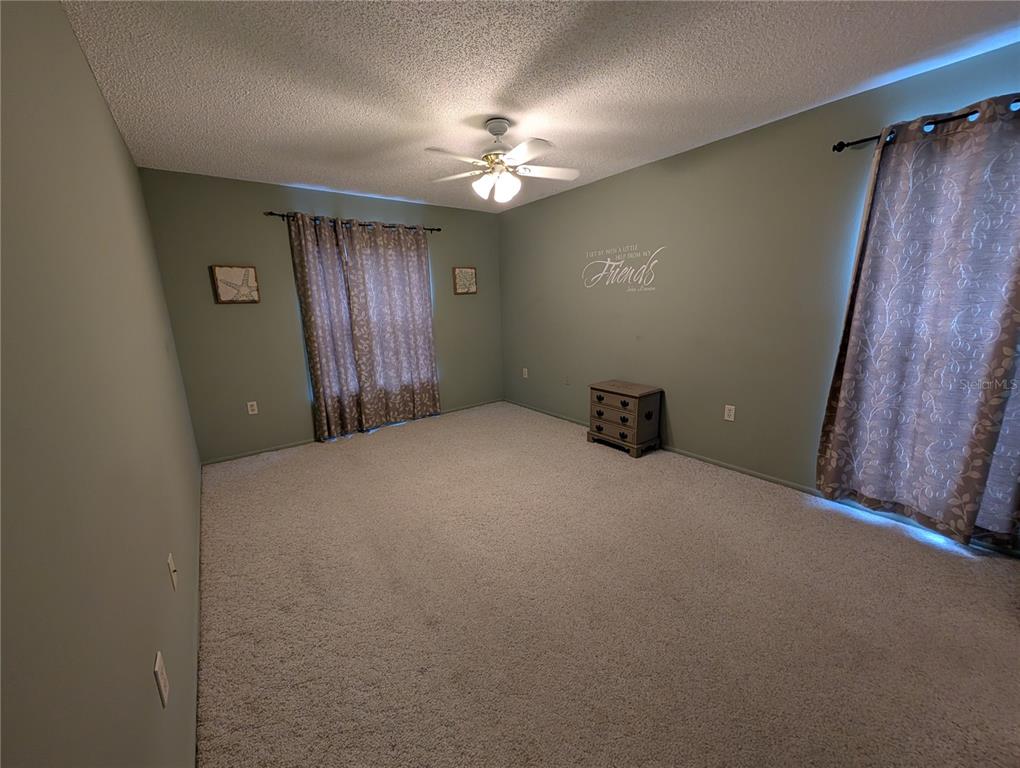 8161 Braddock Circle, Unit 1 Port Richey, FL 34668 - Photo 12 of 27 a view of a livingroom with a ceiling fan and window