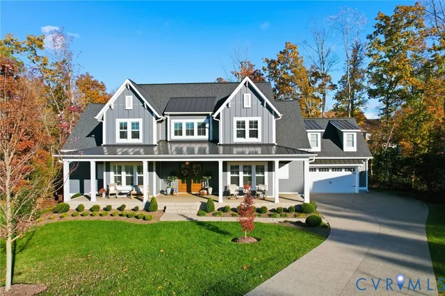 a front view of a house with garden and trees