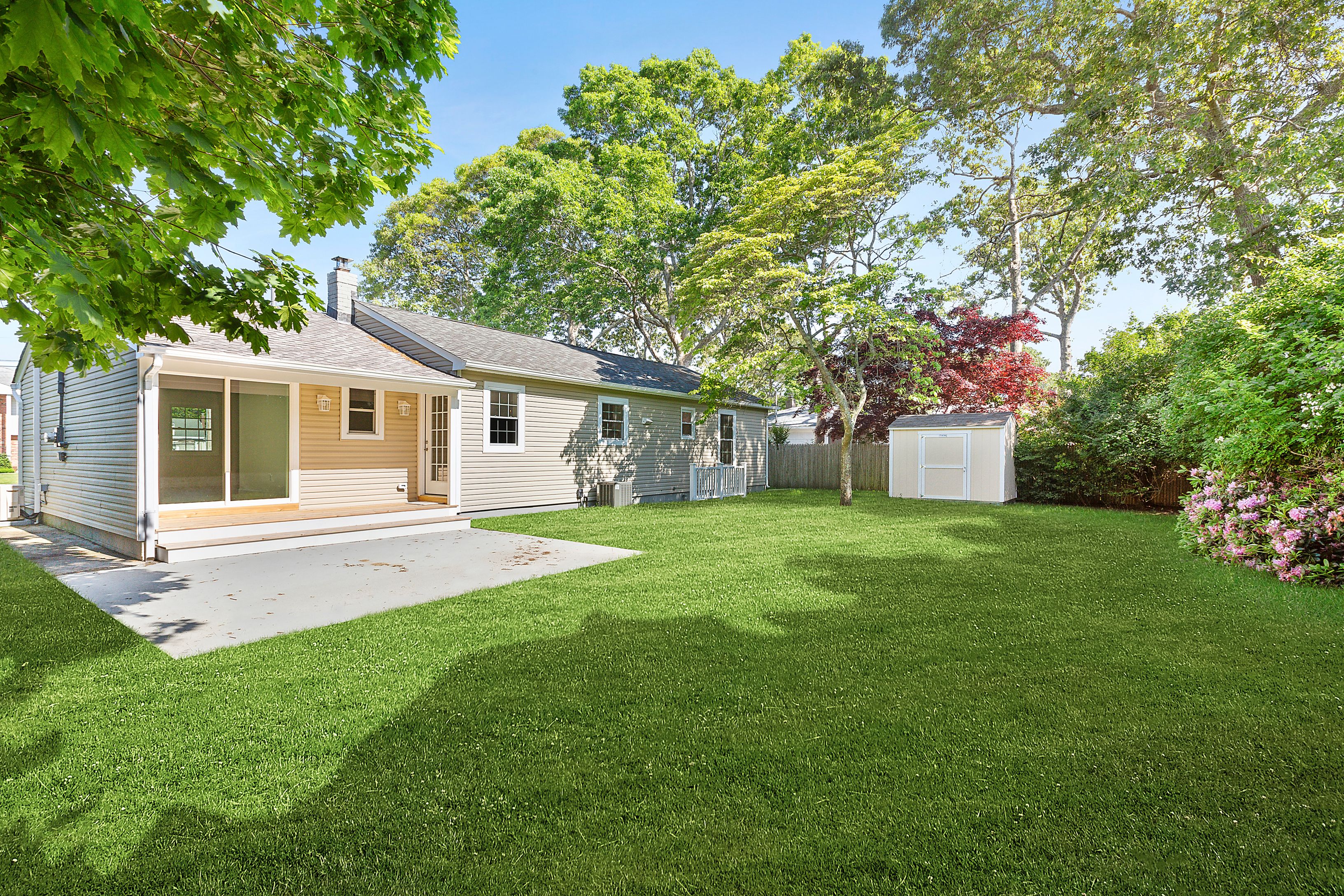 6 Whiting Road East Quogue, NY 11942 - Photo 17 of 18 a front view of a house with a garden