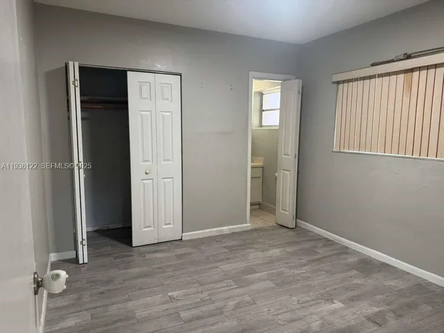 an empty room with windows and closet