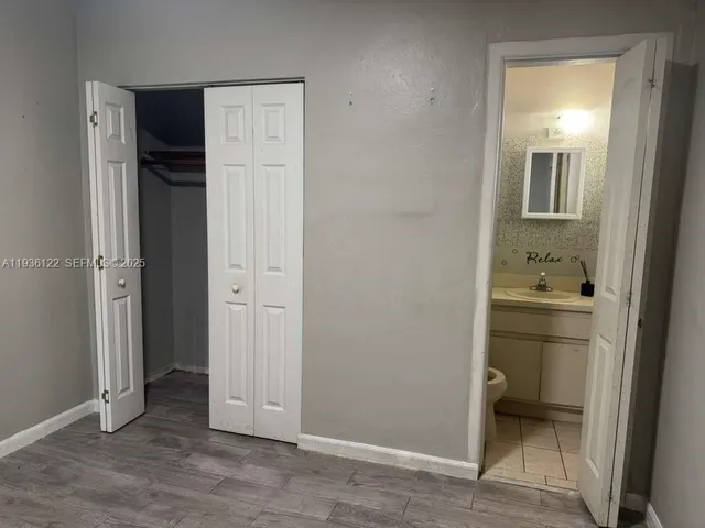 an empty room with closet and wooden floor