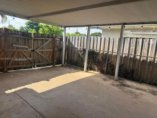 a view of backyard with wooden fence
