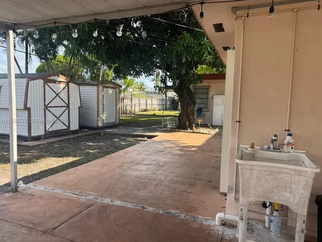 a view of a house with backyard and tree