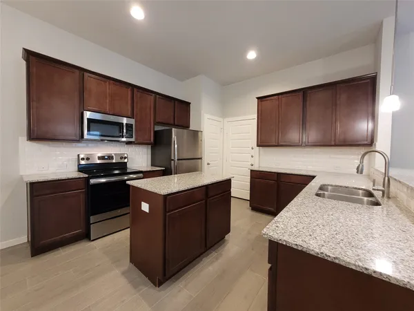 a kitchen with a sink and chandelier