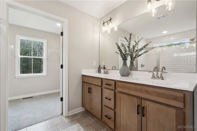 a bathroom with a double vanity sink a mirror and a shower