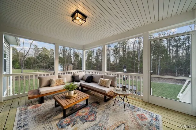 a living room with furniture and a floor to ceiling window